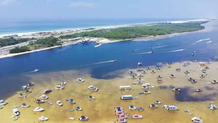 Busy Crab Island near white sandy beaches of Okaloosa Island Grass Flats in Destin, brackish water low tide and pontoons, jet skis, paddleboards, swimming, wading