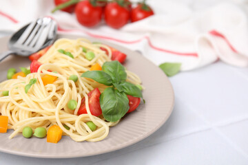 Plate of delicious pasta primavera served on white table, closeup