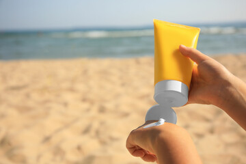 Child applying sunscreen near sea, closeup. Space for text. Sun protection care