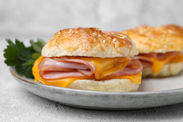 Delicious bagels with ham and cheese on table, closeup