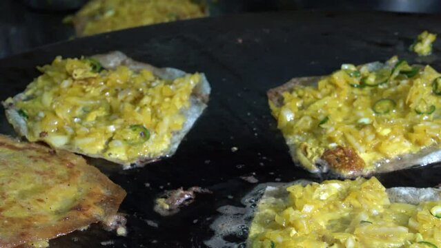 chicken Mataba in cooking process in street food restaurant. It will be prepare for serve to their customer with a bowl of dipping sauce next to it.