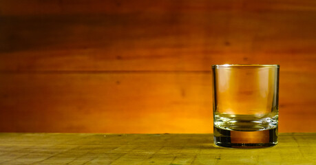 glass of whiskey on wooden background