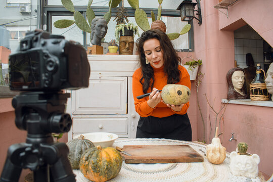 caucasian woman with her digital camera making tutorial for halloween night