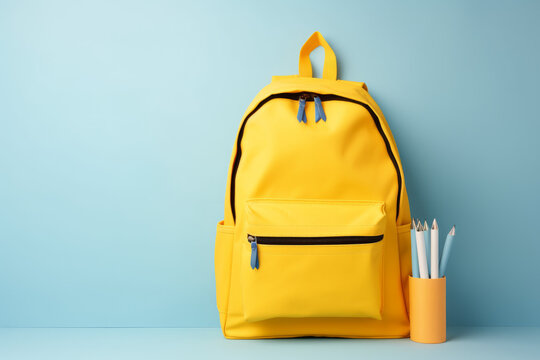Full school backpack with books isolated on blue background with copy space. Back to School concept - Created with Generative AI technology.