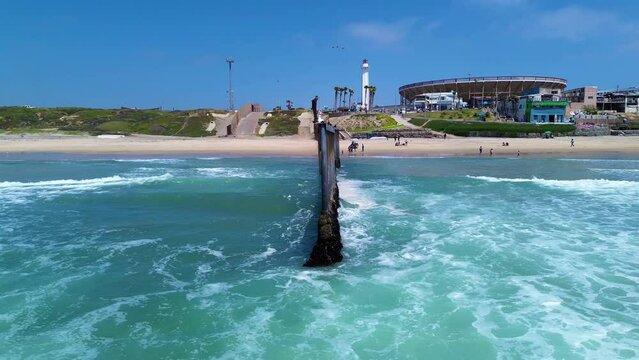 2023 - Excellent aerial view pulling away from a close-up of a seagull resting on the border wall between Mexico and the United States for a full view of the ocean and beaches of both countries.