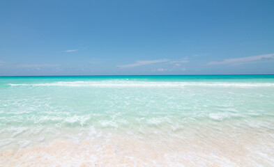 Fototapeta na wymiar Hermosa playa tropical con cielo azul y despejado y vista al mar