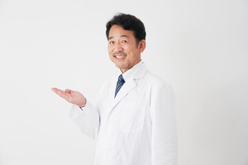 手のひらで左側を指すミドルエイジの医者　白背景