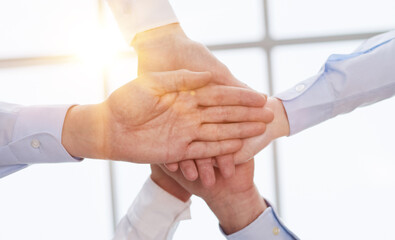 Diverse business team putting their hands together in a huddle of support and motivation