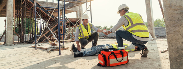 Builder accident fall scaffolding to concrete floor, Safety team help employee accident. First aid worker accident in construction site.