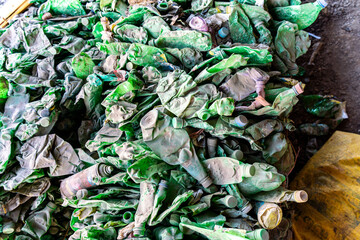 Lots of green plastic bottles and plastic wasted products being smashed on ground for recycle purpose