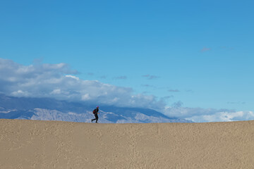 Woman running on the sand dune in Death Valley national park
