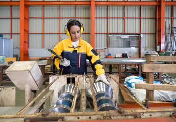 Industrial environment with focus on a diligent worker, engrossed in operating a complex machine...