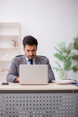 Young male employee and too much work in the office