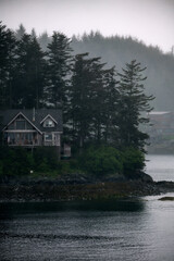 Grey, misty, foggy morning in archipelago near Sitka, Alaska with small islands channel cruising...