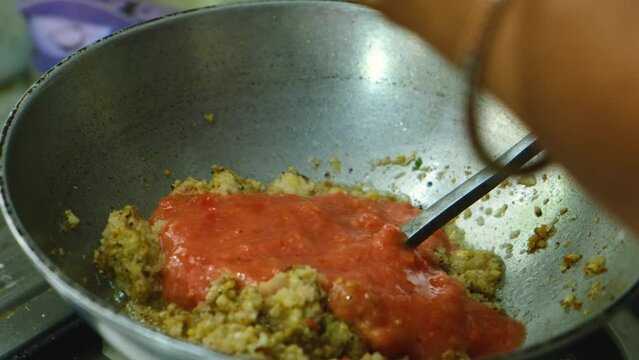 adding tomato paste in frying masala  for the vegetable  Kofta curry an Indian Food, 4k, Close up shot 