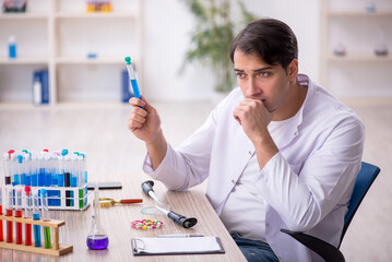 Young male chemist working at the lab