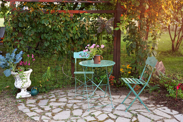 Bistro Table Set in A Summer Cottage Garden at Sunset