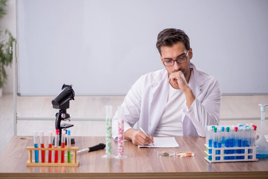 Young male chemist in front of white board