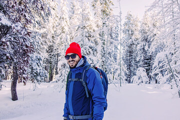 Fototapeta na wymiar Man wearing red beanie smiling outdoors in the winter,