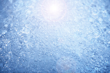 Bubbles and seething water in the light of sunlight.Blue water texture.