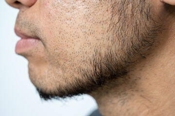 Side view of Asian man face with beard grows on his lower face.