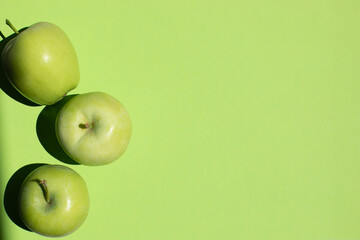 Fresh green apples isolated on greeen background with a place for text