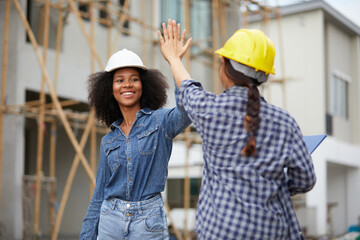 African worker or architect giving hi five pose celebrating success at work on the construction site