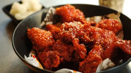 Fotobehang Soy and Spicy Korean fried chicken on a black plate. © wisely