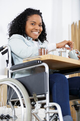 happy young woman in wheelchair eating at home