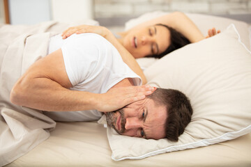 frustrated man cannot fall asleep wife snoring