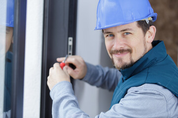 worker fasten the handle to a plastic window