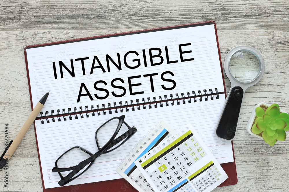 Aufkleber intangible assets . flat lay, top view. diary with calculator and calendar .text on page