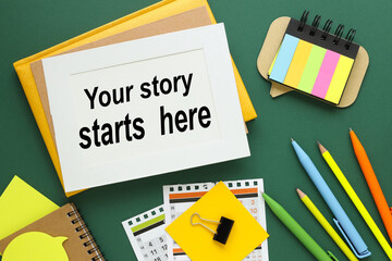 Your Story Starts Here text on white paper in a frame on a green background