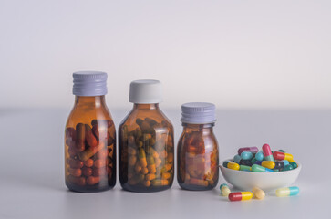  3 bottles of medicine without labels  with medicine cup on a white background