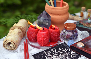 Still life with manuscript, tarot, red candles and witch book. Occult, esoteric and witchcraft concept. Mystic wicca background with vintage objects
