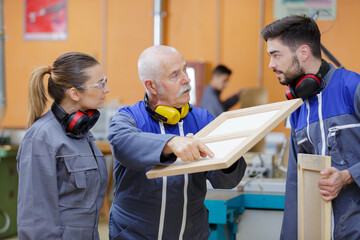 young apprentices with professional carpenter