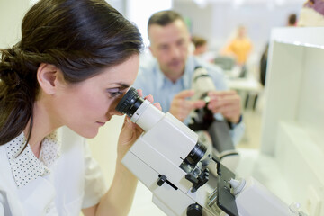 woman with microscope in microelectronics laboratory