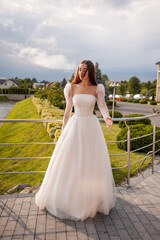 Fototapeta na wymiar Fashion young bride in stylish wedding dress outdoor