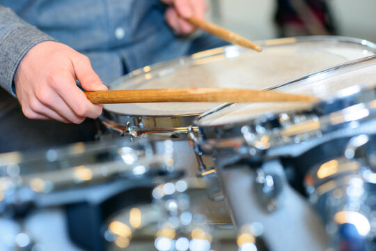 close up of hands playing the drums