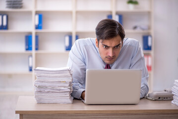 Fototapeta premium Young male employee and too much work in the office