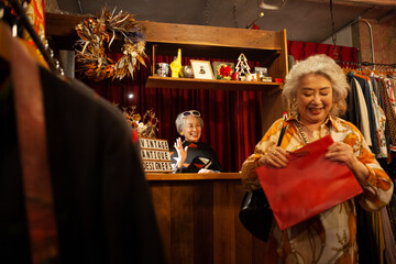 ブティックで買い物をした顧客の女性を見送るオーナー