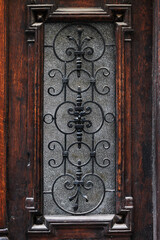 The Old Wooden Door with the Forged Grate