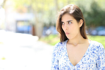 Perplexed woman looking at side in the street
