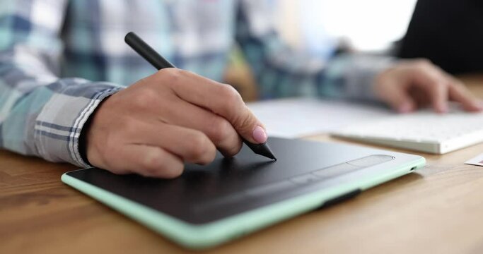 Closeup of graphics tablet and a woman hand. Home freelancer and designer