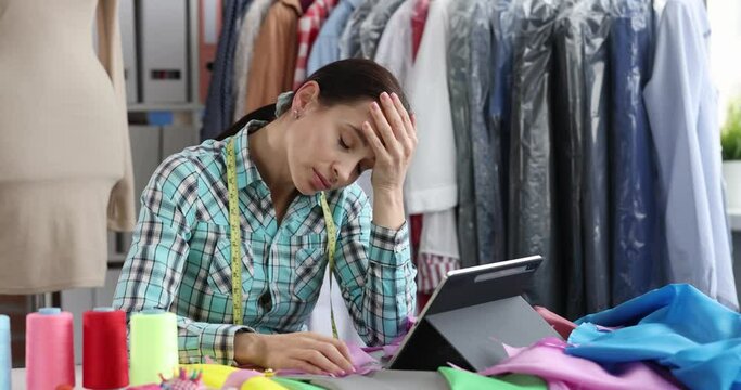 Upset sad seamstress designer stylist at workplace in atelier. Designer creative crisis