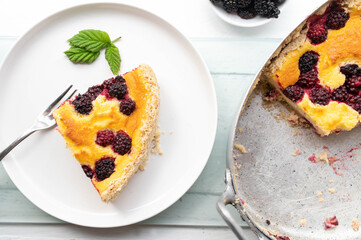A slice of homemade blackberry pie on a white plate. Top view