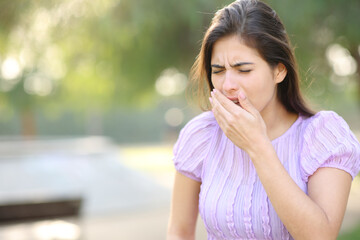 Woman coughing in a park