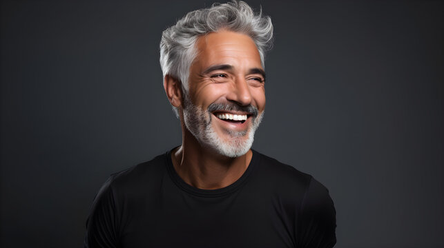 Handsome senior man in black t-shirt with white hair, smiling, displaying vibrant health with great tan skin and white teeth