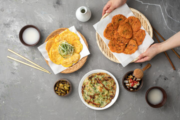 동태전과 파전이 놓여진 테이블에 김치전을 올려두는 모습