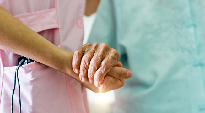 Young girl's hand holding old woman's wrinkled hands